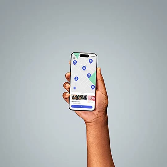 A hand holding an iPhone representing big business franchises