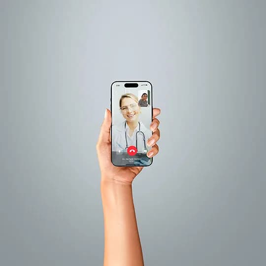 A hand holding an iPhone on a telemedicine call representing the telemedicine industry