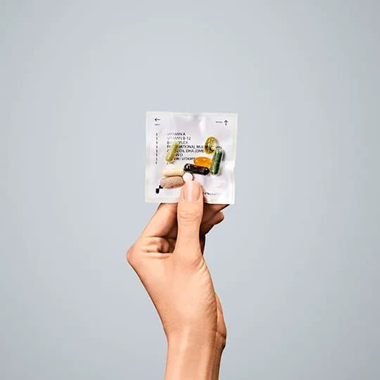 A hand holding a packet of pills representing the online pharmacy industry
