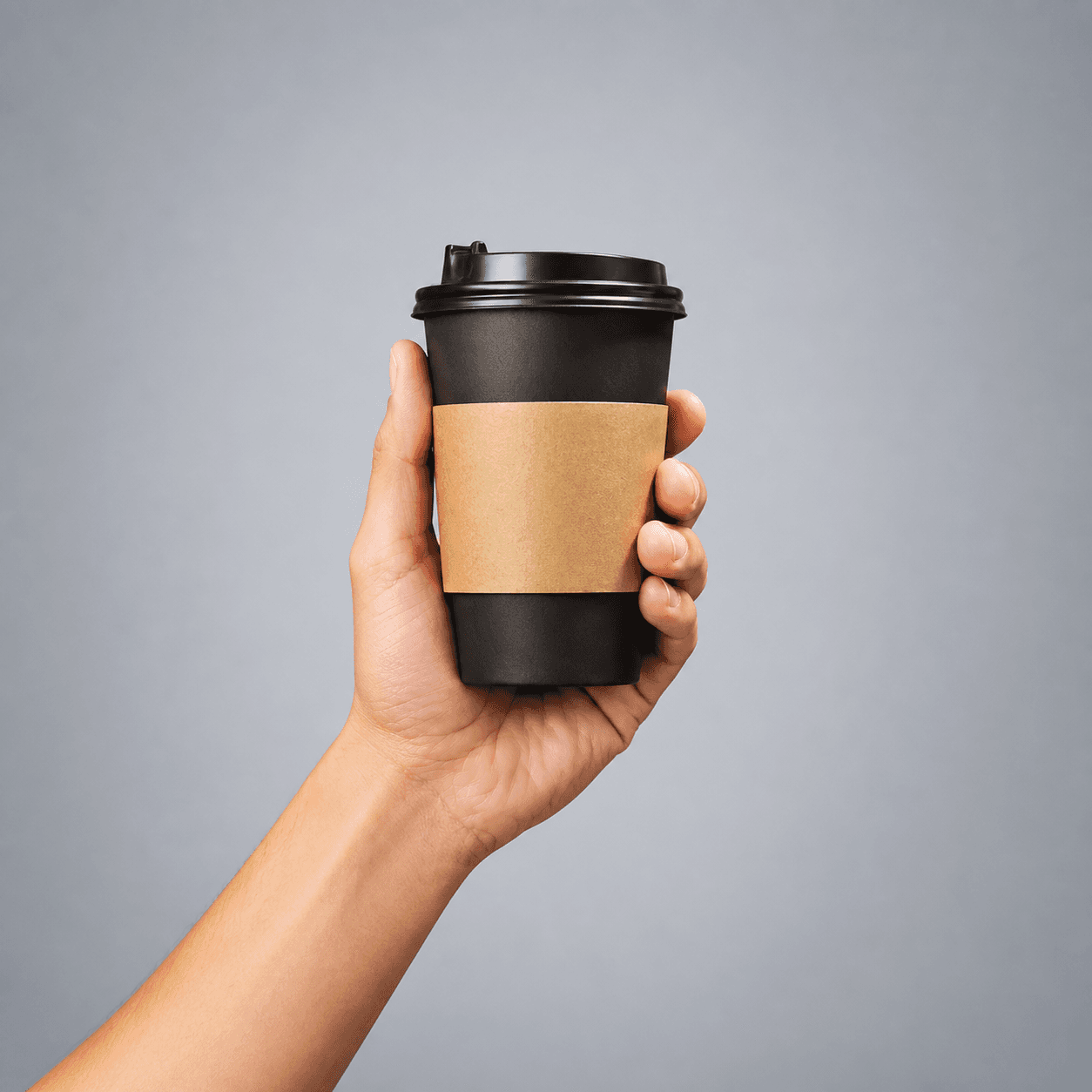 A hand holding a takeaway coffee cup representing the convenience retail industry