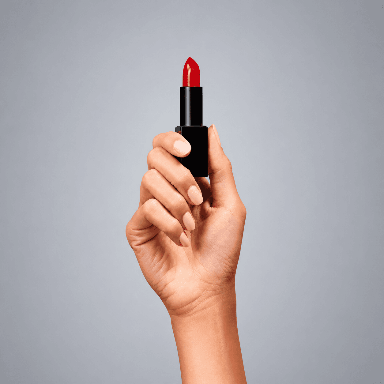 A hand holding lipstick representing the beauty industry