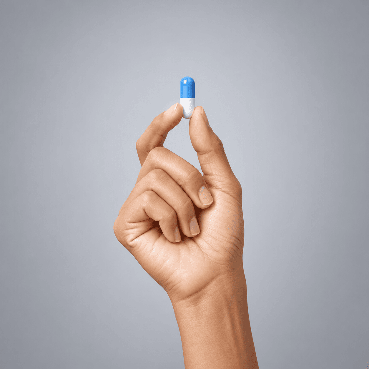 A hand holding a blue and white capsule representing the healthcare industry