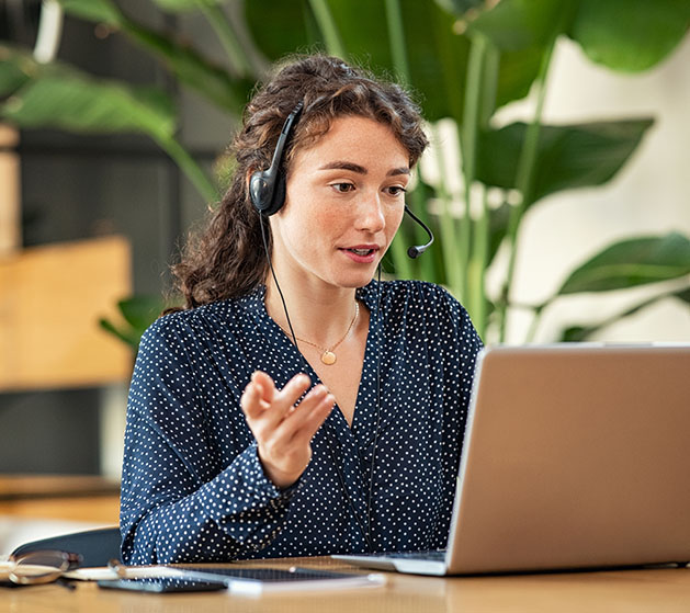 A woman in headphones providing customer support with American PaySave's Payments Hub