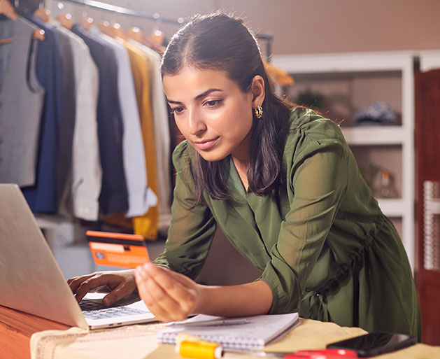 A woman using omnichannel payment processing systems from American PaySave to pay for inventory on her laptop