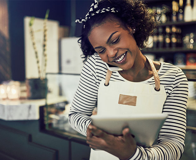 A restaurant hostess on the phone marking down a reservation using American PaySave POS systems
