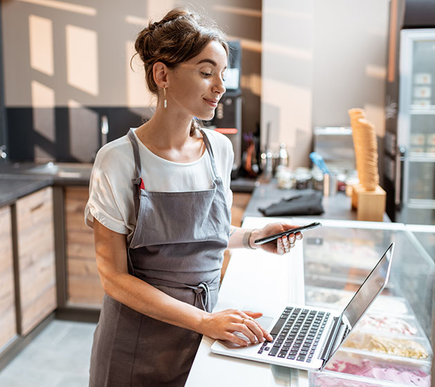A bakery owner reviewing her online's store's online commander center from American PaySave's POS systems