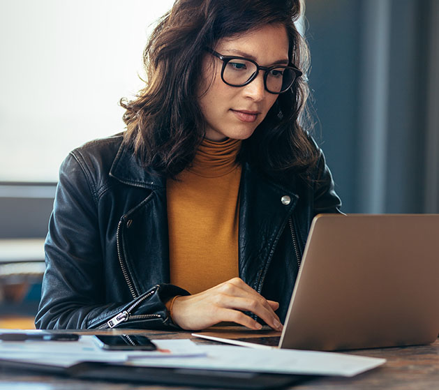 A female web developer working on her laptop reviewing American PaySave POS software