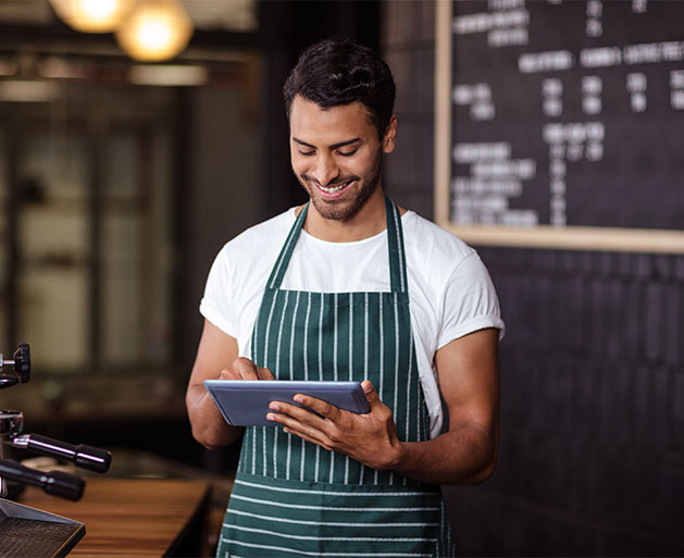 A barista reviewing orders with ease thanks to American PaySave's easy to use POS ticket system