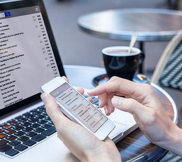 A person on their phone reviewing automated email reports from American PaySave's POS systems